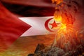 conical volcano blast eruption at night with explosion on Western Sahara flag background, problems of natural disaster and