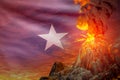 Conical volcano eruption at night with explosion on Somalia flag background, troubles because of natural disaster and volcanic