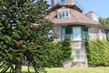 A conifer tree in front of an unusual historic sixteen sided house on a beautiful sunny summers day in Devon, England Royalty Free Stock Photo