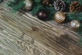 Coniferous branches, along with cones and toys for the Christmas tree, lie diagonally on an old wooden table Royalty Free Stock Photo