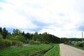 Coniferous deciduous forest. Water channel. Road. Village house. Blue sky with