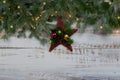 Coniferous spruce branches with snow and decoration on white abraded boards. Natural Christmas and winter background or concept.