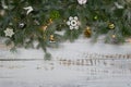 Coniferous spruce branches with snow and LIGHT CHAIN white abraded boards. Natural Christmas and winter background or concept.