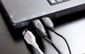 Connect USB cable to laptop computer on black desk. Royalty Free Stock Photo