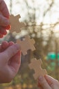 Connect wooden puzzles into a single whole in the evening at sunset as a symbol of unity, friendship, loyalty