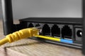 Connected cable to router on wooden table, closeup. Wireless internet communication