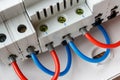 Connected by colored wires automatic circuit breakers closeup in the white plastic mounting box Royalty Free Stock Photo