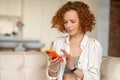 Cute ginger woman with a smartphone in hands