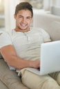 Connected living is comfortable living. Portrait of a relaxed young man using a laptop on the sofa at home. Royalty Free Stock Photo