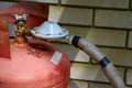 Connected metal gas cylinder against a white brick wall in a country house Royalty Free Stock Photo