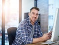 Connected to every opportunity for business. Portrait of a happy young businessman using a phone at his office desk.