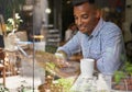 Connecting with his mates. a young african man using his mobile phone in a coffee shop. Royalty Free Stock Photo