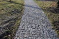 Connecting the park path and sidewalk to the asphalt road using a strip of concrete blocks with protrusions for the blind. they kn Royalty Free Stock Photo