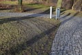 Connecting the park path and sidewalk to the asphalt road using a strip of concrete blocks with protrusions for the blind. they kn Royalty Free Stock Photo