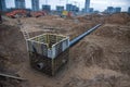 Connecting a trench drain to a concrete manhole structure at construction site.