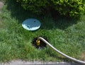 Connecting water sprinkler hose, pop-up sprinkler system to a water supply under a plastic lid in the lawn