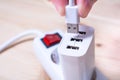 Connecting A White USB Cable To A White USB Charger Which Is Plugged Into A Power Strip Royalty Free Stock Photo