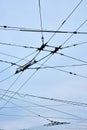 Connecting wires for clean city transportation upward abstract view with overcast blue sky