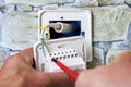 Connecting wires to wall thermostat for floor heating system, an electrician uses crosshead screwdriver for installation Royalty Free Stock Photo