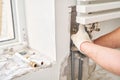 Work As A Plumber, mounting water heating radiator on the white wall indoors. connection heating pipes to white Radiator Royalty Free Stock Photo