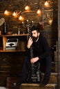 Connection through music. Man bearded musician enjoy evening with bass guitar, wooden background. Guy sits thoughtful Royalty Free Stock Photo