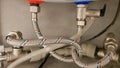 Connection of water supply, hot and cold water to the boiler. Hose for hot and cold water in the bathroom. Plumbing Royalty Free Stock Photo