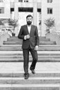 Conquer business world. Office worker confidently step on stairs. Bearded man going to work. Business man in modern city Royalty Free Stock Photo