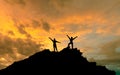 The conquest of the summit, the silhouettes of two people on top of the mountai