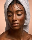 Consecrated but Im not devout. Closeup shot of a beautiful young woman with her hair wrapped in a towel against a brown