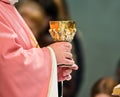 Consecration of wine in the hands of the priest who addresses th