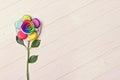 Consept image of cup of coffee, macaron and flower on white wooden background. Rainbow rose. Set of multicolored macarons