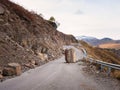 The consequences of an earthquake on a mountain highway. Large granite boulder fell on the road. Dangerous mountain road after