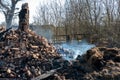 The consequences of a fire in an old wooden country house. Ashes and burnt boards close-up. Coming smoke from a burning house Royalty Free Stock Photo