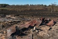 The consequences of a forest fire. The remains of a burnt-out old wooden house in Ukraine. Ashes and burnt things are lying on the Royalty Free Stock Photo