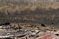 The consequences of a forest fire. The remains of a burnt-out old wooden house in Ukraine. Ashes and burnt things are lying on the Royalty Free Stock Photo