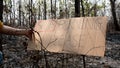 A conservative sentence on cardboard banners in area of the burning forest and firefighters extinguish fires.