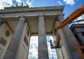 A conservator performs restoration work on the Brandenburg Gate in Berlin using a hydraulic lift on a clear spring day. Royalty Free Stock Photo