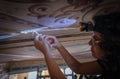 Conservator restoring intricate ceiling art. Royalty Free Stock Photo