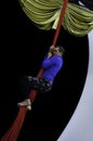 A male acrobat climbs up an aerial silk