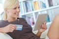 Considering her next purchase. a beautiful woman doing some online shopping at home using her digital tablet. Royalty Free Stock Photo