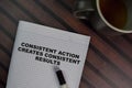 Consistent Action Creates Consistent Results write on a book isolated on Wooden Table