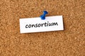 Consortium. Word written on a piece of paper, cork board background Royalty Free Stock Photo