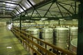 Barrels and technical equipment inside the wine cellar of a winery, Cape Town, South Africa.