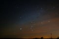 The constellation Orion in the starry sky in a cloudy haze.