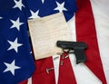 Constitution with Hand Gun & Cartridges on American Flag Royalty Free Stock Photo