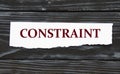 CONSTRAINT - word on a torn piece of paper on a black wooden background