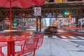Constrasting scene of red table setting and umbrella on island in mid busy city street Royalty Free Stock Photo