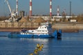 Construction on the banks of the river. A cargo tug goes down the river. Extraction of river sand