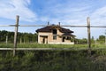 Construction of brick family house in suburbs. Shell of town home with completed walls and roof. Building a home in the field Royalty Free Stock Photo