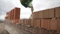 The construction of a brick house. The builder lays a wall of brick. The builder smears the mortar on the brick. Multi-colored Royalty Free Stock Photo